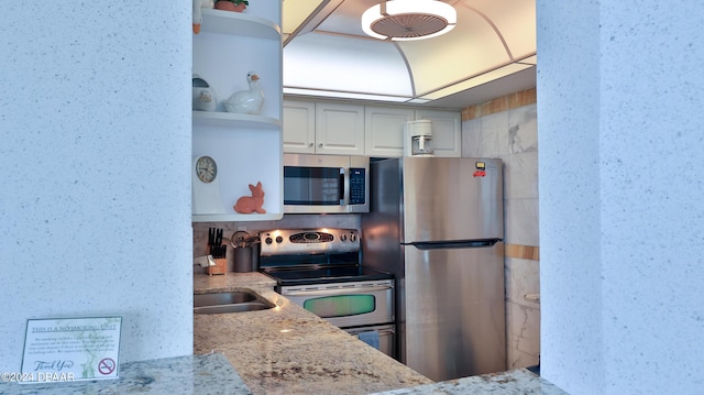 2625 S Atlantic Ave Unit 24Nw, Daytona Beach Shores, FL 32118 - kitchen with appliances with stainless steel finishes, open shelves, light stone counters, white cabinets, and a sink