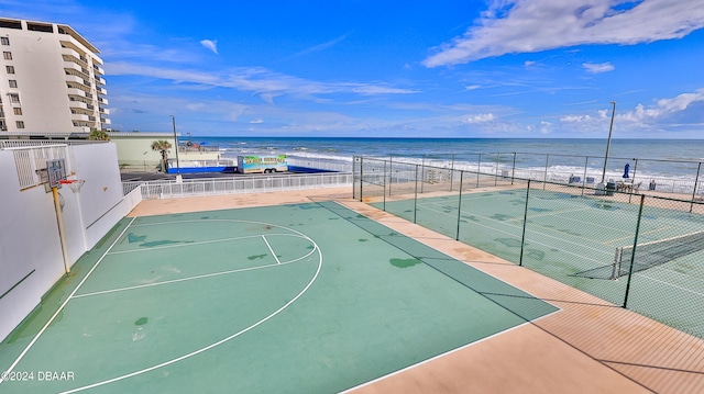 view of basketball court featuring a view of the beach and a water view