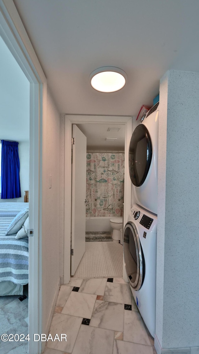 2625 S Atlantic Ave Unit 24Nw, Daytona Beach Shores, FL 32118 - washroom with stacked washer / dryer, baseboards, and light marble finish flooring