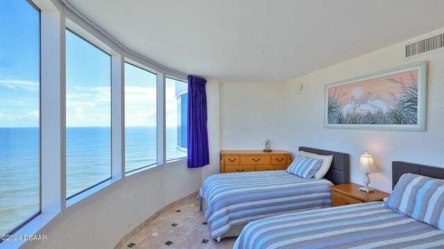 bedroom with access to exterior and a water view