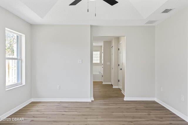 spare room with light wood-type flooring, plenty of natural light, ceiling fan, and lofted ceiling