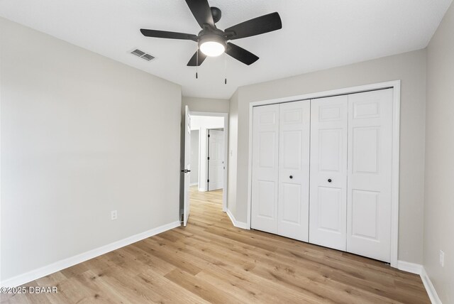 unfurnished bedroom with light wood-type flooring, a closet, and ceiling fan