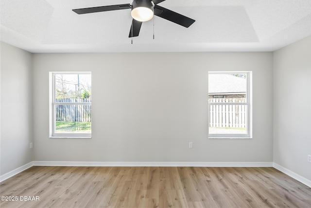 empty room with light wood-type flooring and a textured ceiling