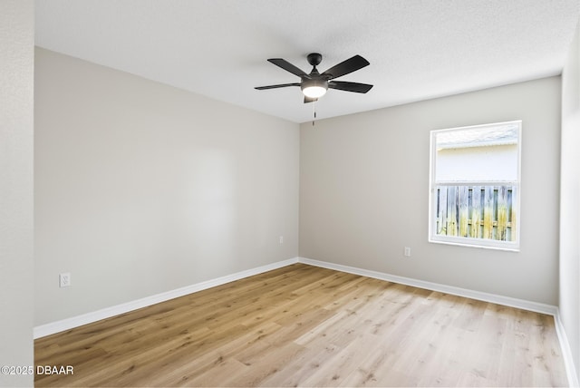 spare room with ceiling fan, light hardwood / wood-style floors, and a textured ceiling