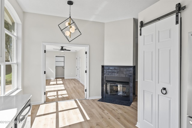 interior space featuring light wood-type flooring, ceiling fan, and a barn door