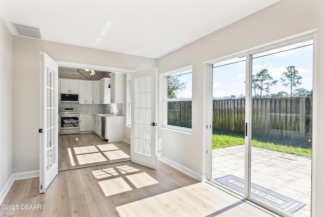 entryway with sink, french doors, and light wood-type flooring