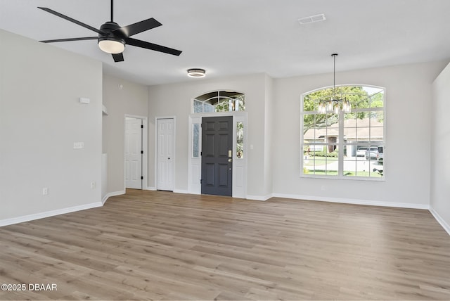 entrance foyer featuring ceiling fan with notable chandelier and light hardwood / wood-style flooring