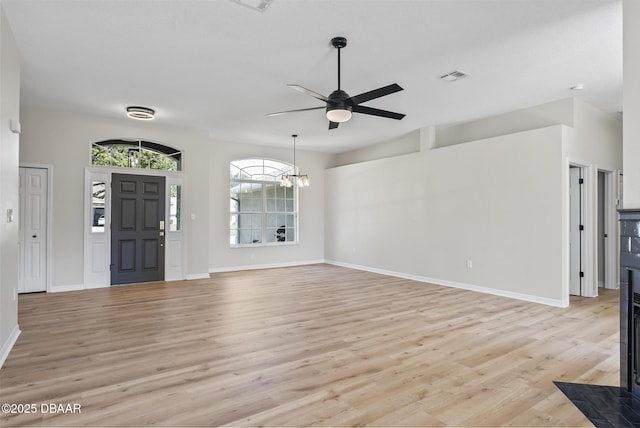 entryway with ceiling fan with notable chandelier and light hardwood / wood-style flooring