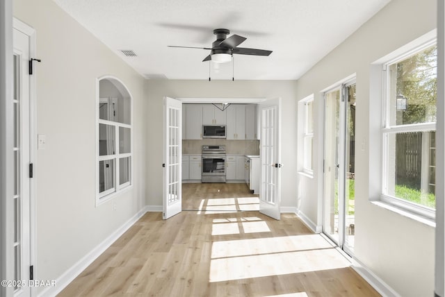 doorway to outside featuring ceiling fan, light hardwood / wood-style floors, and french doors