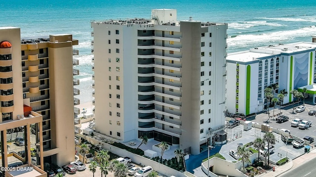 view of building exterior featuring a water view and a beach view