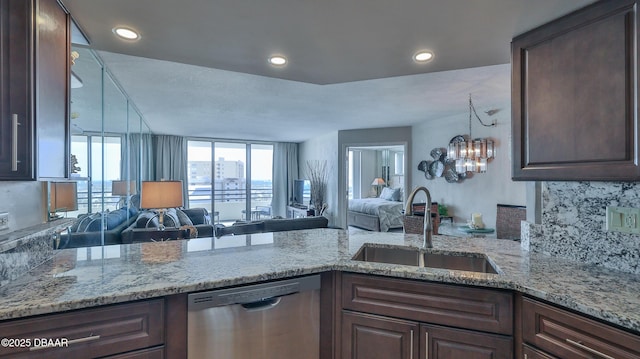 kitchen with sink, dark brown cabinets, dishwasher, light stone countertops, and decorative backsplash