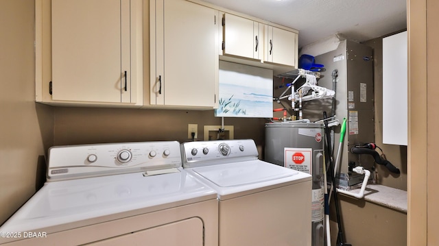 laundry room with cabinets, washer and clothes dryer, and water heater