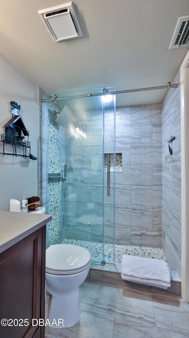 bathroom with vanity, toilet, and a shower with shower door