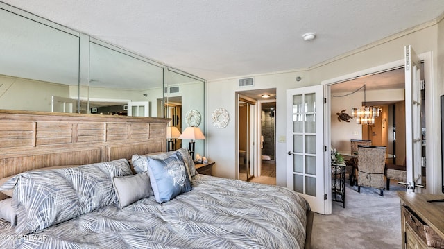 carpeted bedroom with a chandelier and a textured ceiling