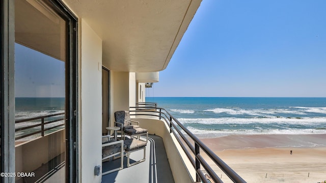 balcony with a water view and a beach view