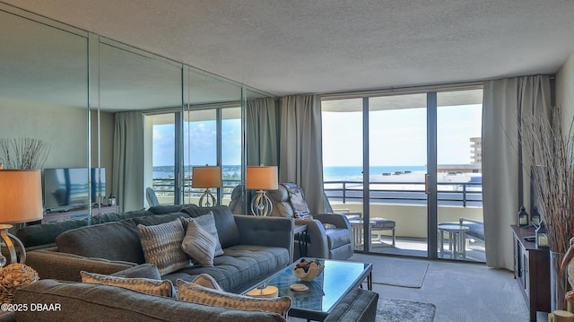 carpeted living room with a textured ceiling, a wall of windows, a healthy amount of sunlight, and a water view