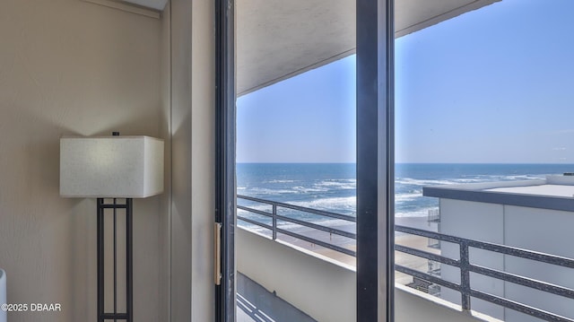 balcony with a water view and a view of the beach