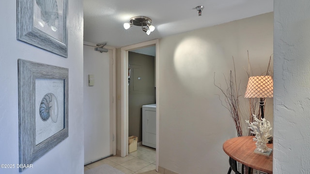 corridor featuring washer / clothes dryer and light tile patterned floors