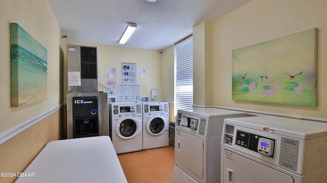 clothes washing area featuring washing machine and dryer and a textured ceiling