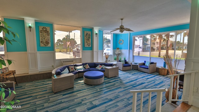 carpeted living room with ceiling fan and a healthy amount of sunlight