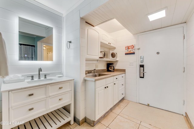 kitchen featuring light tile patterned floors, white cabinetry, and sink