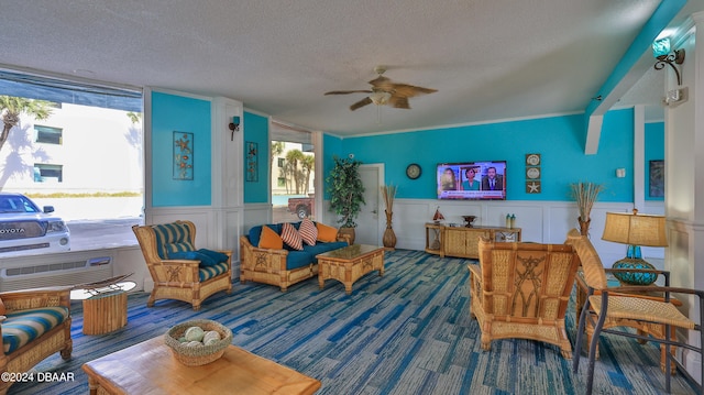 living area featuring ceiling fan, a textured ceiling, and carpet