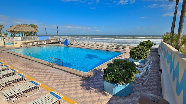 view of pool with a water view, a patio area, and a gazebo