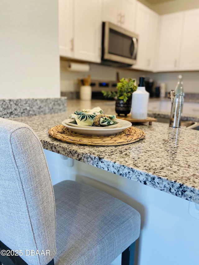 1323 Cork Dr, Ormond Beach, FL 32174 - kitchen featuring stainless steel microwave and white cabinetry