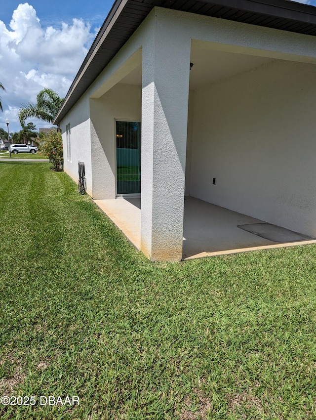 3103 Nova Scotia Way, New Smyrna Beach, FL 32168 - view of side of property featuring stucco siding, a lawn, and a patio area