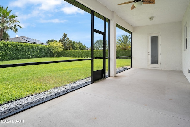 unfurnished sunroom with ceiling fan