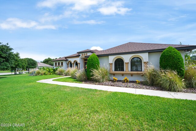 mediterranean / spanish home featuring a front lawn