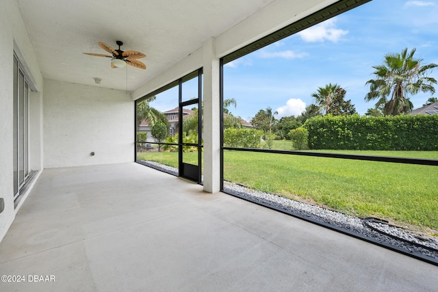 unfurnished sunroom featuring ceiling fan