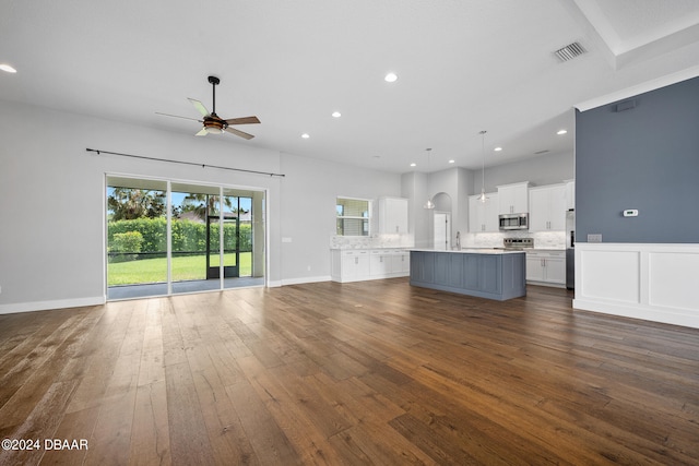 unfurnished living room with dark wood-type flooring and ceiling fan