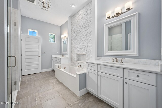 bathroom featuring vanity, a textured ceiling, and separate shower and tub