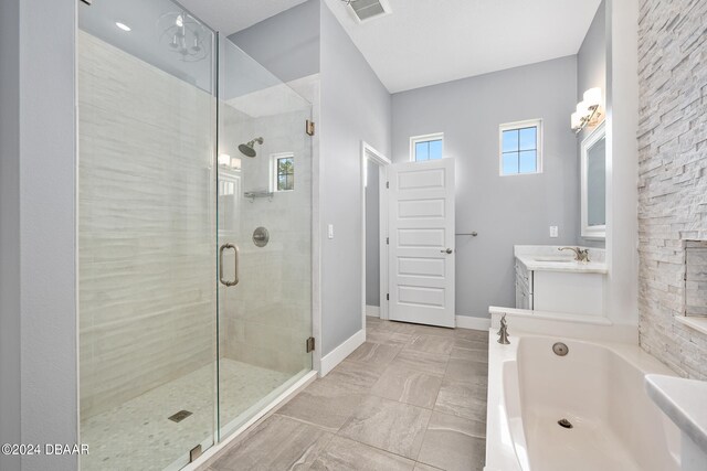 bathroom with tile patterned flooring, vanity, and separate shower and tub