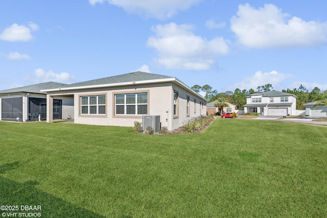 view of side of home with a garage, a yard, and central AC