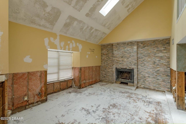 unfurnished living room featuring vaulted ceiling with skylight