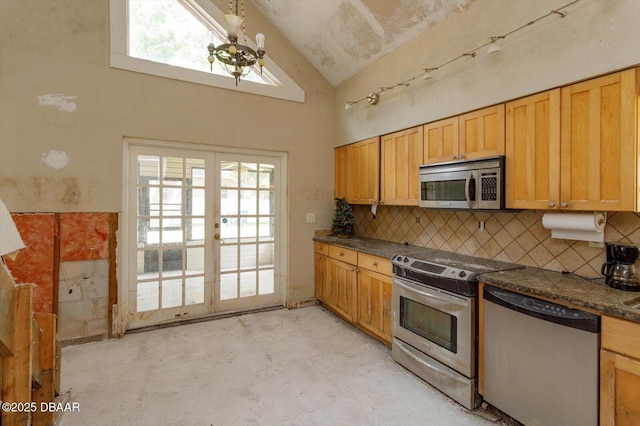 kitchen featuring a notable chandelier, appliances with stainless steel finishes, tasteful backsplash, french doors, and high vaulted ceiling