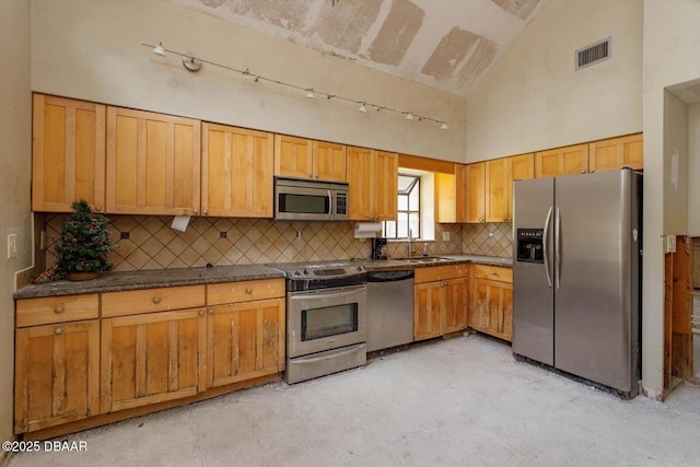 kitchen with tasteful backsplash, high vaulted ceiling, and appliances with stainless steel finishes