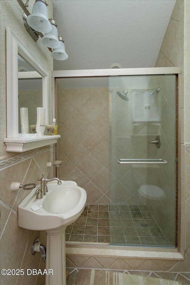 bathroom featuring toilet, walk in shower, and tasteful backsplash