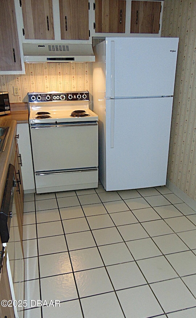 100 Silver Beach Ave Unit 710, Daytona Beach, FL 32118 - kitchen with white appliances, wallpapered walls, under cabinet range hood, light tile patterned flooring, and light countertops