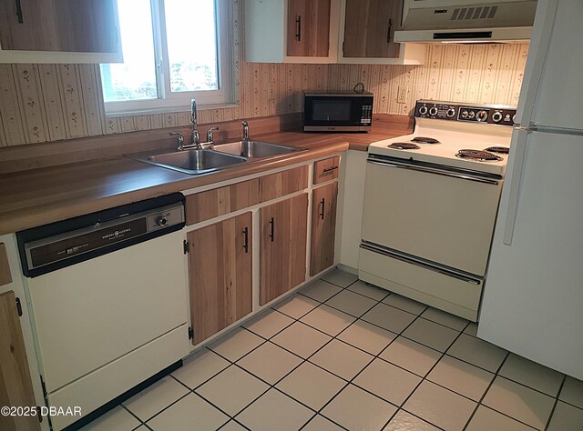 100 Silver Beach Ave Unit 710, Daytona Beach, FL 32118 - kitchen featuring white appliances, under cabinet range hood, a sink, and light tile patterned floors