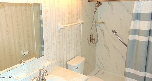100 Silver Beach Ave Unit 710, Daytona Beach, FL 32118 - bathroom featuring a marble finish shower, wallpapered walls, toilet, and vanity