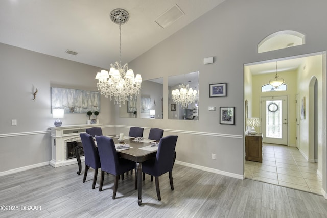 30 Foxfield Look, Ormond Beach, FL 32174 - dining room featuring visible vents, wood finished floors, baseboards, high vaulted ceiling, and a chandelier