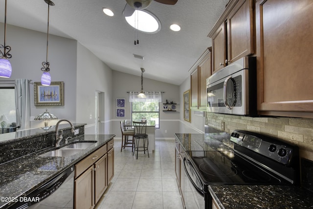 30 Foxfield Look, Ormond Beach, FL 32174 - kitchen with a textured ceiling, decorative light fixtures, vaulted ceiling, a sink, and stainless steel appliances