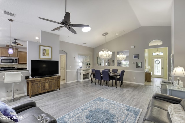 30 Foxfield Look, Ormond Beach, FL 32174 - living room featuring visible vents, baseboards, high vaulted ceiling, ceiling fan with notable chandelier, and light wood finished floors