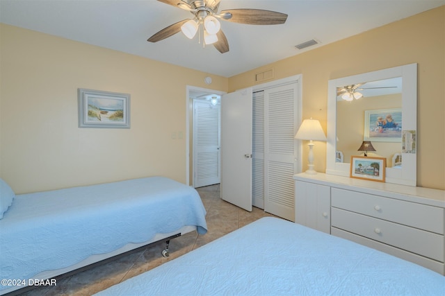 bedroom with ceiling fan, a closet, and light tile patterned floors