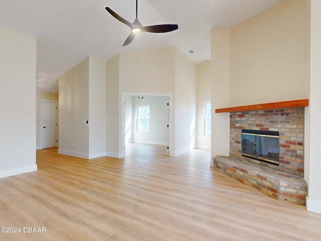 804 Soft Pine Ct, New Smyrna Beach, FL 32168 - unfurnished living room with high vaulted ceiling, a ceiling fan, light wood finished floors, a fireplace, and baseboards