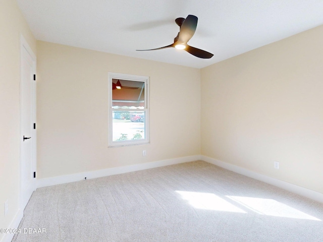 spare room featuring light carpet and ceiling fan