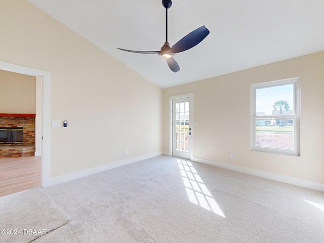 804 Soft Pine Ct, New Smyrna Beach, FL 32168 - spare room with vaulted ceiling, light carpet, ceiling fan, a brick fireplace, and baseboards